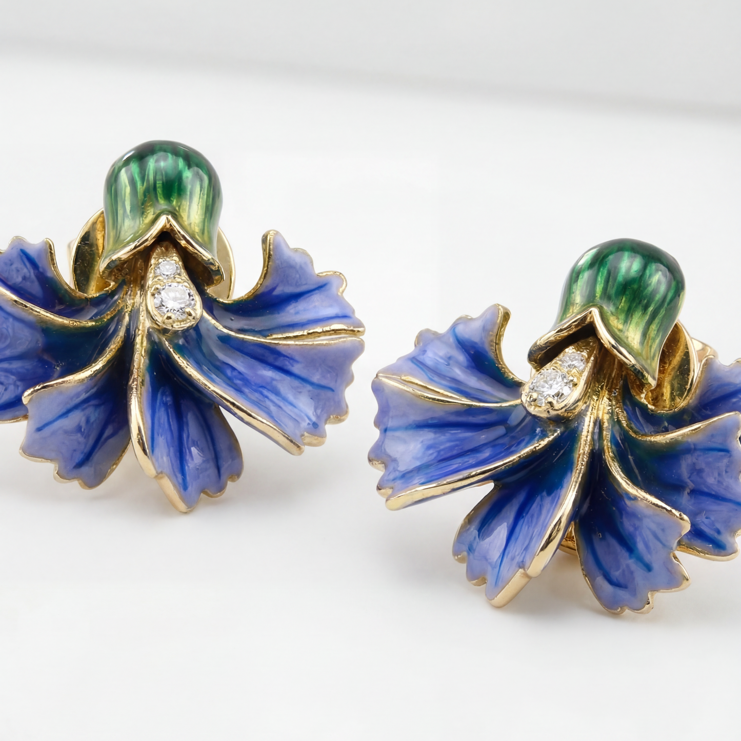 Pair of blue floral earrings with gold accents on a white background