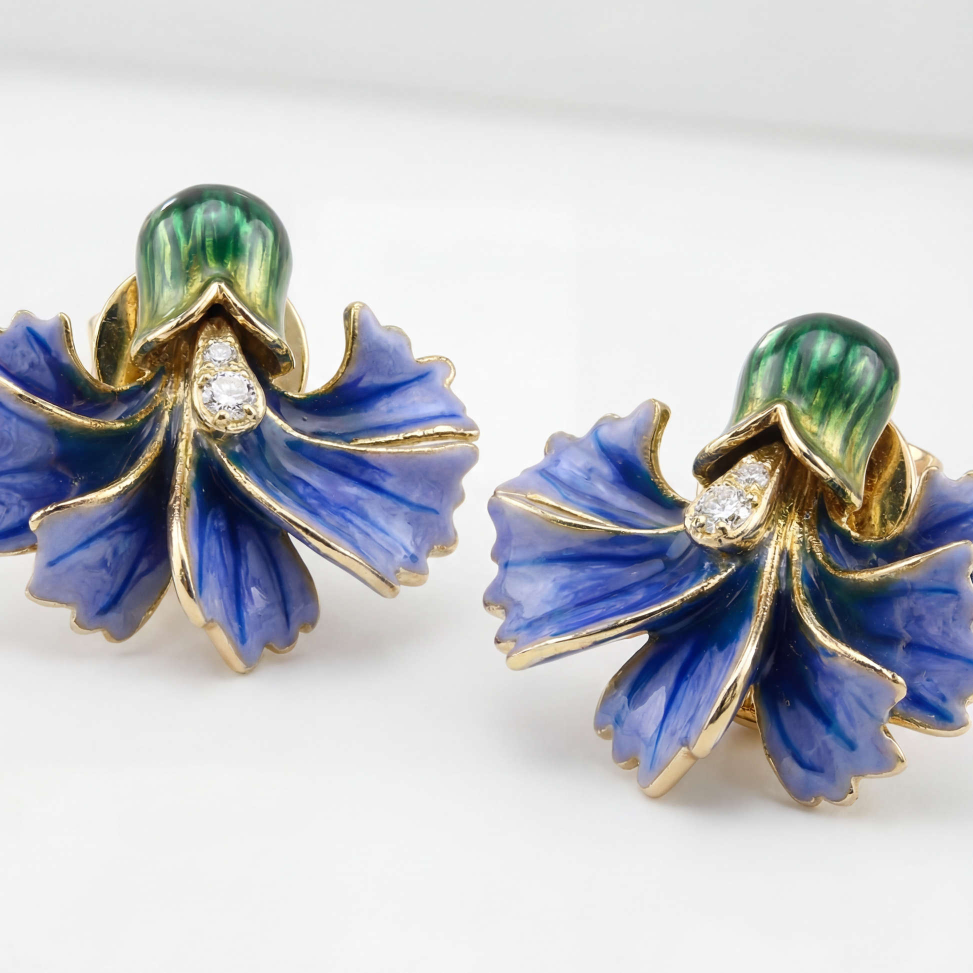 Pair of blue floral earrings with gold accents on a white background